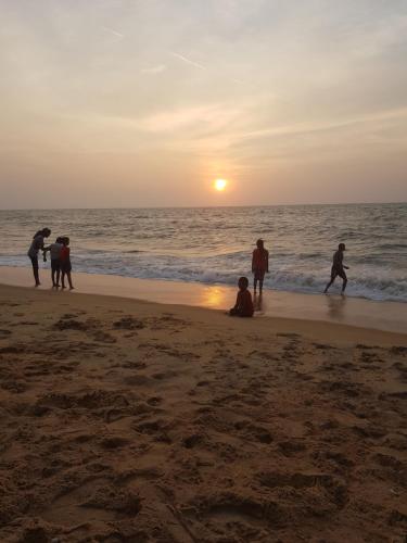 a group of people playing on the beach at sunset at Familyhouse in Negombo