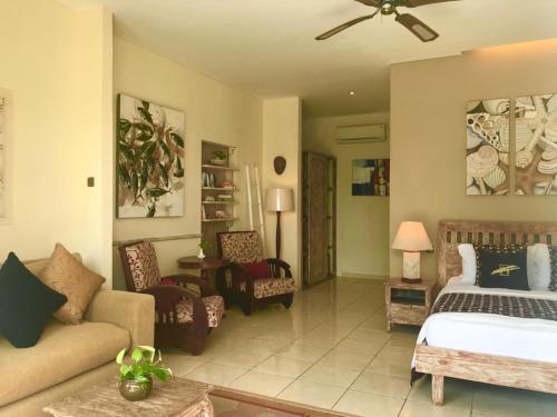 a bedroom with a bed and a living room at Tauch Terminal Resort Tulamben & Spa in Tulamben