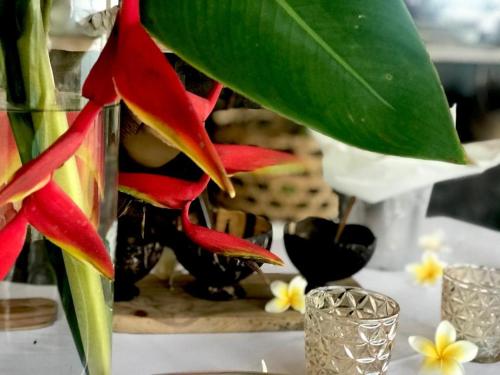 a table with a vase with flowers in it at Tauch Terminal Resort Tulamben & Spa in Tulamben