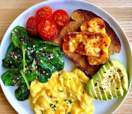 a plate of food with eggs and tomatoes and toast at Tauch Terminal Resort Tulamben & Spa in Tulamben