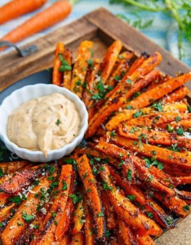 a tray of carrots with a bowl of dipping sauce at Tauch Terminal Resort Tulamben & Spa in Tulamben