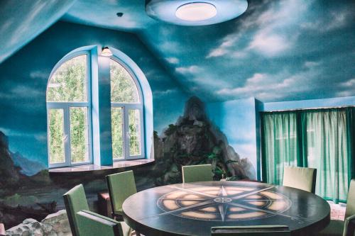 uma sala de jantar com uma mesa e um quadro na parede em Отель Вышеград em Vyshhorod