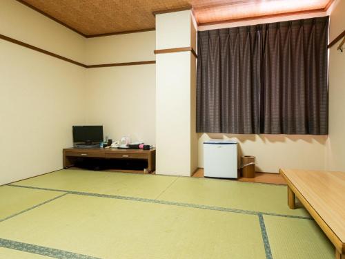 Habitación vacía con escritorio y ventana en Tabist Hotel Kurama Hikone en Takamiya