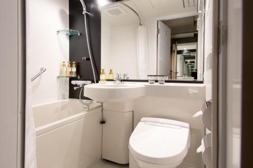 bagno bianco con servizi igienici e lavandino di Kobe Plaza Hotel West a Kobe