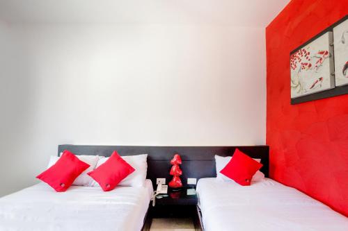 a room with two beds with red and white pillows at Quinta Santa Anita in Playa del Carmen