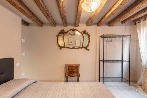 um quarto com uma cama e um espelho na parede em ANDREA Venice FLAT 3rd Floor em Veneza