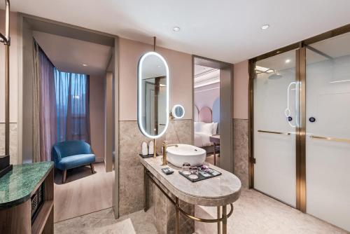 a bathroom with a sink and a mirror at Mercure Nanjing Downtown in Nanjing