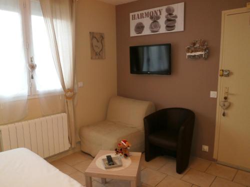a small living room with a couch and a chair at Au 14 Honfleur parking privé in Honfleur