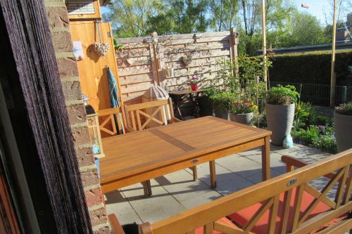 シャルボイツにあるLuett Huesの木製テーブルと椅子付きのパティオ