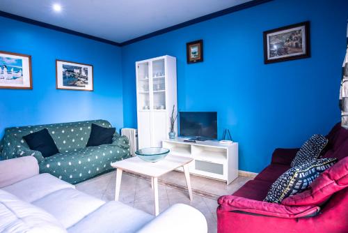 a blue living room with a couch and a table at Apartaments Yaco in Lloret de Mar