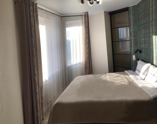 sypialnia z dużym łóżkiem i oknem w obiekcie PaulMarie Apartments on Chigrinova 3 w Mohylewie
