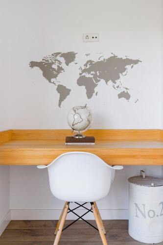 a world map on a wall with a white chair at Luxury Villa Beach & Golf in San Juan de Alicante