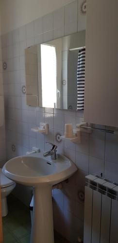 bagno con lavandino, specchio e servizi igienici di Casa Nella a Ledro