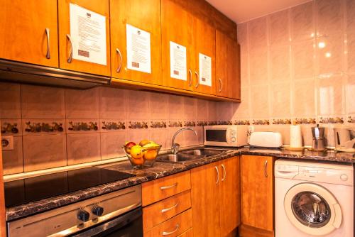 a kitchen with a sink and a washing machine at Apartaments Yaco in Lloret de Mar
