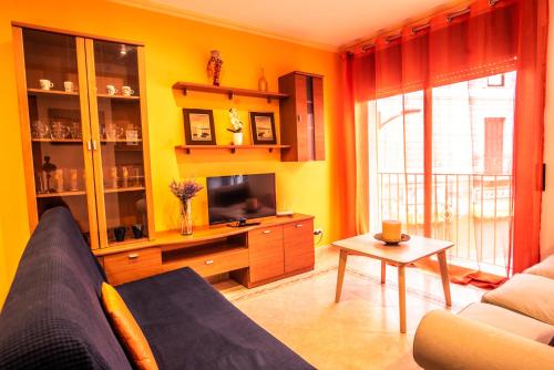 a living room with a couch and a tv at Apartaments Yaco in Lloret de Mar