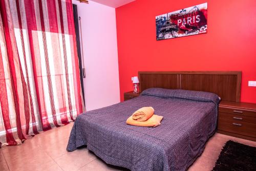 a bedroom with a bed with a yellow towel on it at Apartaments Yaco in Lloret de Mar