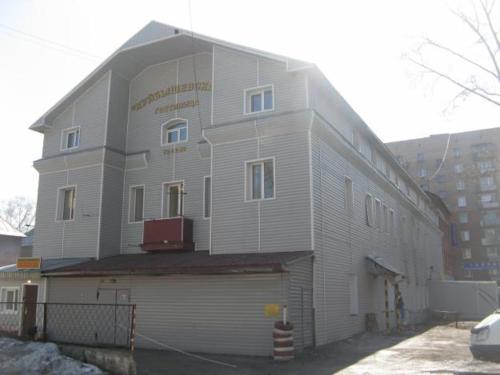 un gran edificio blanco con un gran garaje en Hotel Kuibyshevskaya, en Novokuznetsk