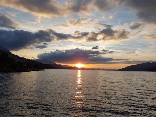 una puesta de sol sobre un gran cuerpo de agua en Hotel Kreuz, en Leissigen