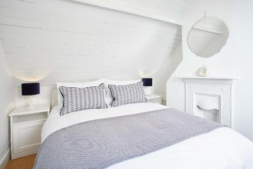 biała sypialnia z łóżkiem i 2 poduszkami w obiekcie Host & Stay - Gun Gutter House w mieście Staithes