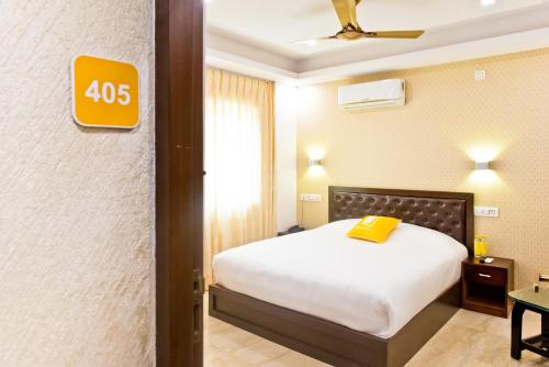 a bedroom with a bed and a yellow sign on the wall at X by Bloom l Indiranagar in Bangalore