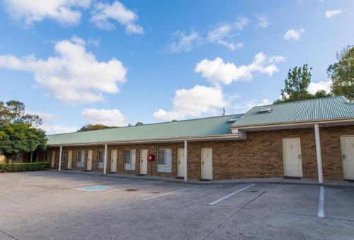 a large brick building with a parking lot at Best Western Mill Park Motor Inn in Morang