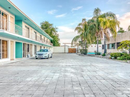 a car parked in a parking lot in front of a building at Capital O Hotel La Siesta, Gomez Palacio in Gómez Palacio