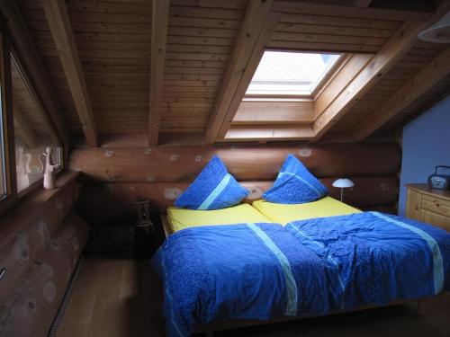 a bedroom with a bed with blue and yellow at Blockhaus-Ferienwohnung in Oppenau