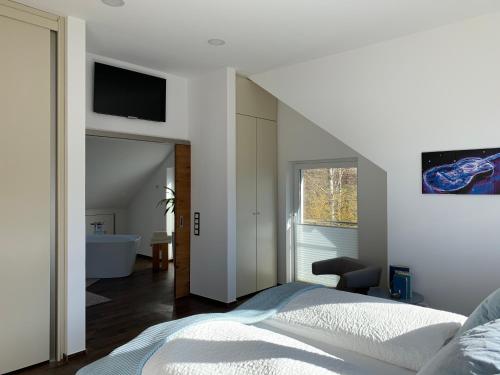 um quarto com uma cama e uma televisão na parede em Luxus-Ferienwohnung Saalhausen em Saalhausen