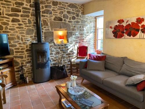 a living room with a couch and a stone wall at Maison d'hôtes & Gîtes Domaine de la Garaye in Dinan