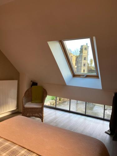 a attic room with a bed and a window at Maison d'hôtes & Gîtes Domaine de la Garaye in Dinan