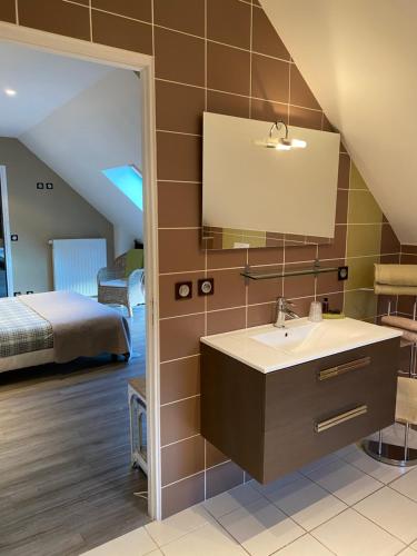 a bathroom with a sink and a bed in a room at Maison d'hôtes & Gîtes Domaine de la Garaye in Dinan