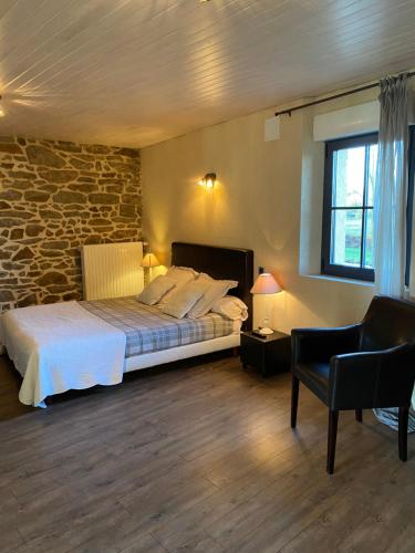 a bedroom with a bed and a stone wall at Maison d'hôtes & Gîtes Domaine de la Garaye in Dinan