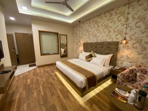 a hotel room with a bed and a chair at Royal Mansion in Kulu