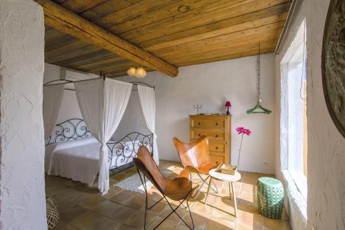 a bedroom with a bed and chairs in a room at LAS MARIPOSAS in San Antonio