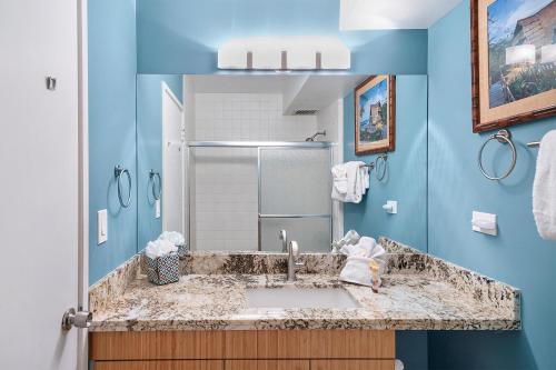 a bathroom with a sink and a blue wall at Mana Kai 410 - Ocean front at Keawakapu Beach, AC in Wailea