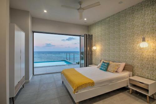 a bedroom with a bed and a view of the ocean at Luxury St Croix Home with Oceanfront Pool and Views in Slob