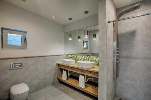 łazienka z 2 umywalkami i prysznicem w obiekcie Luxury St Croix Home with Oceanfront Pool and Views w mieście Slob