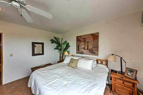 a bedroom with a white bed and a ceiling fan at Cabo Condo with Balcony, Ocean Views and Resort Perks! in Cabo San Lucas