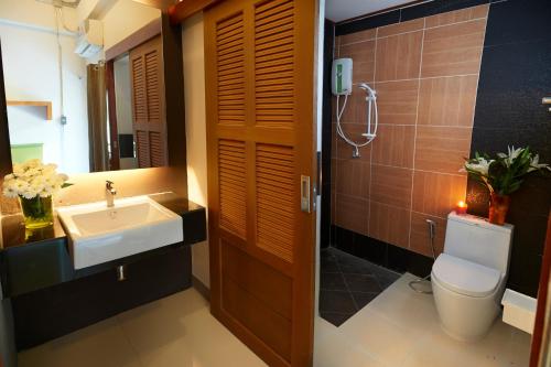 y baño con lavabo, aseo y espejo. en Euanjitt Chill House, en Khon Kaen