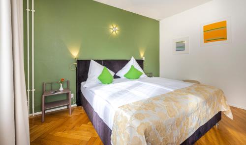 a bedroom with a large bed with green walls at Hotel Oltnerhof - Self Check in in Olten