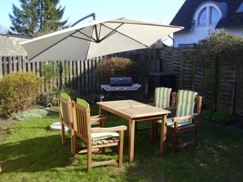 a table and chairs with an umbrella in a yard at Ferienwohnung Am Stadtrand in Dwasieden