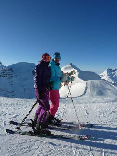 two people on skis standing on a snow covered slope at Hotel Lech & Residenz Chesa Rosa in Lech am Arlberg