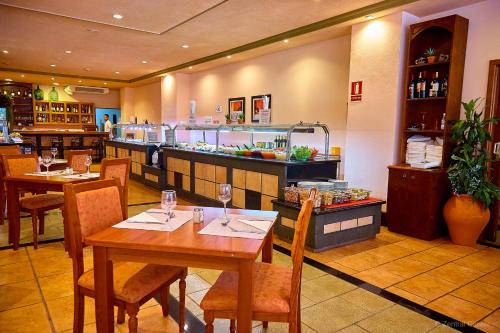 a restaurant with wooden tables and chairs and a counter at Hotel Zentral Center - Adults only in Playa de las Americas