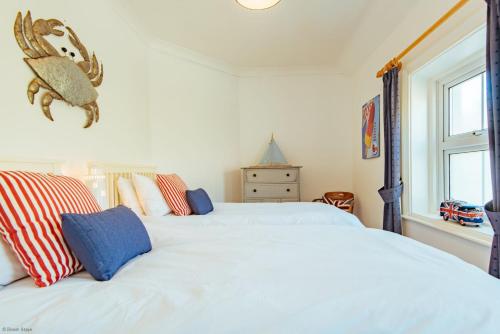 1 dormitorio con 2 camas blancas y ventana en Driftwood Cottage by Bloom Stays, en Folkestone