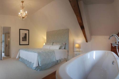 a bedroom with a bed and a bath tub at Manoir du Bois Mignon Luxury Home - Dordogne in Le Fleix