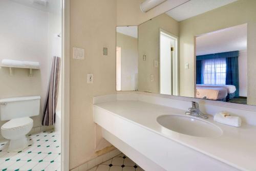 a bathroom with a sink and a toilet and a mirror at La Quinta Inn by Wyndham Phoenix Thomas Road in Phoenix