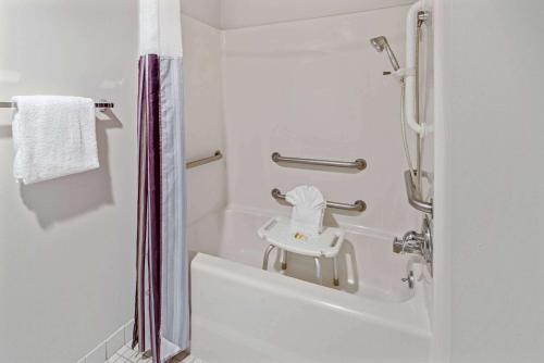 baño blanco con ducha y lavamanos en La Quinta by Wyndham Naples East (I-75), en Naples