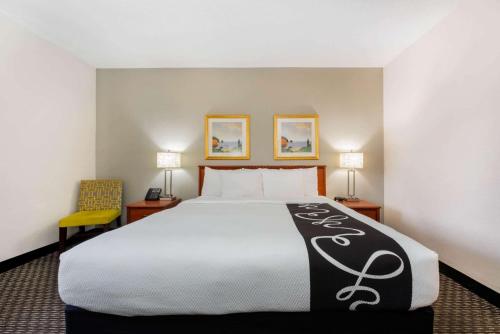 a hotel room with a large bed and two lamps at La Quinta Inn by Wyndham Ft. Lauderdale Tamarac East in Fort Lauderdale