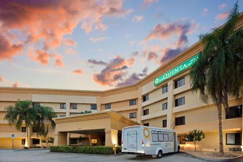 uma carrinha branca estacionada em frente a um hotel em La Quinta by Wyndham Miami Airport East em Miami