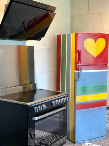 une cuisine avec une cuisinière et un réfrigérateur avec une télévision dans l'établissement Le Logis de la Tour Saint Jacques, à Chouzé-sur-Loire